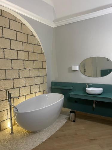 een badkamer met een groot wit bad en een wastafel bij M&M Guest House in Ercolano