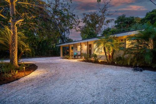 a house with a gravel driveway in front of it at Beautiful Glam Mid-Century 1 block from Sarasota bay with Firepit in Sarasota