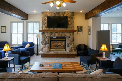 a living room with a stone fireplace with a tv at Crested Butte Hostel in Crested Butte