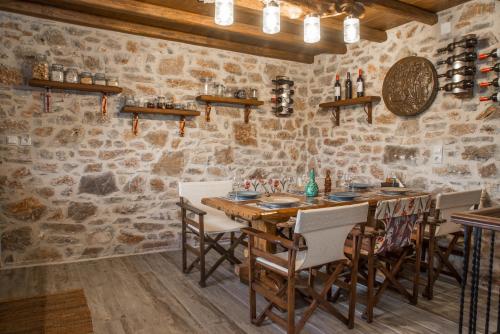 jadalnia z kamiennymi ścianami oraz stołem i krzesłami w obiekcie Karyoupolis Lounge Cave House w mieście Gythio