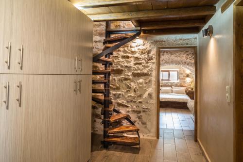 a staircase in a room with a stone wall at Karyoupolis Lounge Cave House in Gythio