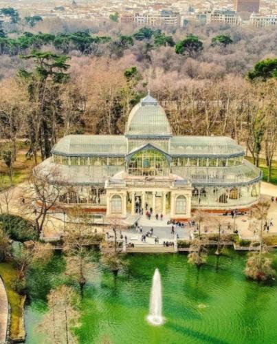 a large building with a fountain in the middle of a pond at APARTAMENTO MADRID Norte in San Sebastián de los Reyes