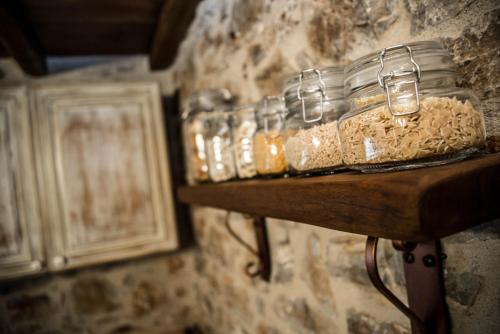 a group of glass jars sitting on a shelf at Karyoupolis Lounge Cave House in Gythio
