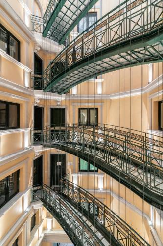 a spiral staircase in a building with reflections in the water at ExAnimo Luxury Apartments in Zakynthos Town