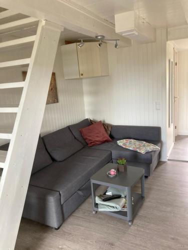 a living room with a couch and a staircase at Gustavsro i Apelviken Annex 1 in Varberg