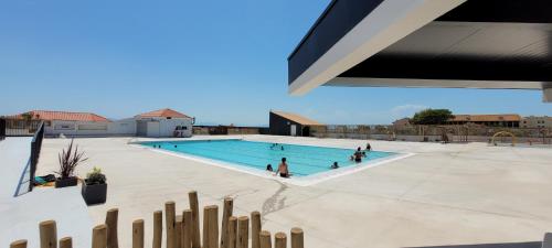 un gruppo di persone in piscina di bel Appartement vue sur le lac marin avec WIFI et piscine a Le Barcarès