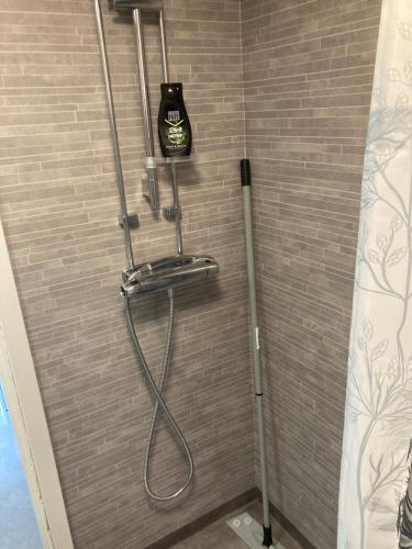 a shower with a black shower head and a showertaining at Gustavsro i Apelviken Annex 1 in Varberg