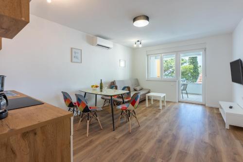 a kitchen and dining room with a table and chairs at Luxury Apartments Lovorka 1 & 2**** in Selce