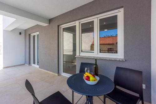 a dining room with a table with a bowl of fruit on it at Luxury Apartments Lovorka 1 & 2**** in Selce