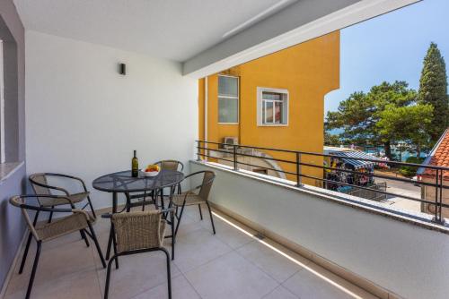 a patio with a table and chairs on a balcony at Luxury Apartments Lovorka 1 & 2**** in Selce
