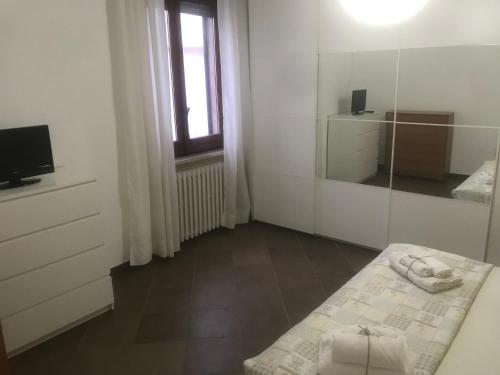 ein weißes Zimmer mit einem Bett und einem Spiegel in der Unterkunft Casalhouse Apartment in Brindisi