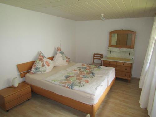 Schlafzimmer mit einem Bett, einer Kommode und einem Spiegel in der Unterkunft Ferienwohnung Liesel in Hornberg