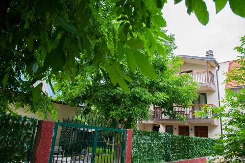 a building with a fence and trees in front of it at Guest House Alte in Kolašin