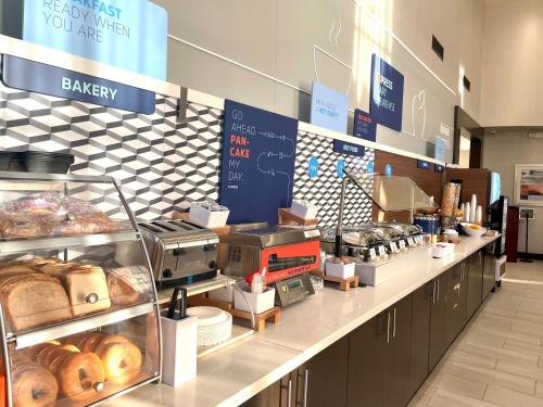 a counter with a variety of pastries on it at Holiday Inn Express Hotel & Suites Hermosa Beach, an IHG Hotel in Hermosa Beach