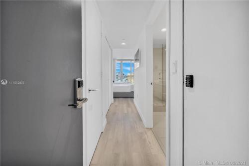 a hallway with white walls and a wooden floor at BeachWalk Studio Apmt 2 Beds, Amazing Views 2010B in Hallandale Beach