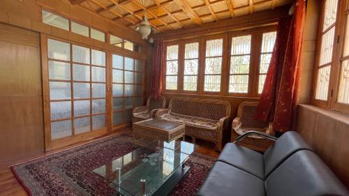 a living room with a couch and a table and windows at THE WILLOW HOUSE in Leh