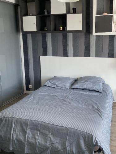 - une chambre avec un lit et une couette grise dans l'établissement Studio Les Voiles de la Baule, à La Baule