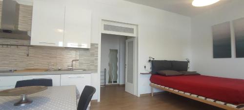 a room with a bed and a table and a kitchen at Casa vacanze Lucilla in Cecina
