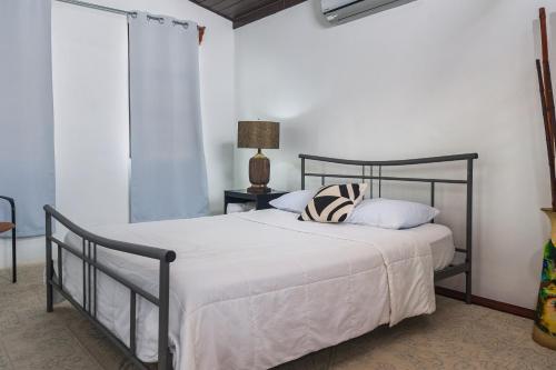 1 dormitorio con cama negra con sábanas y almohadas blancas en Hotel Cañas, en Cañas