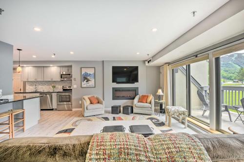 a living room with a couch and a kitchen at Walk to Lifts and Village! Killington Mountain Condo in Killington