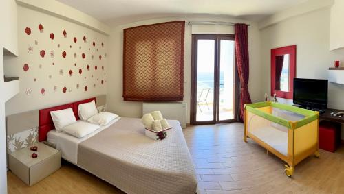 a bedroom with a large bed and a television at Lindos Anatoli Luxury Villa in Líndos