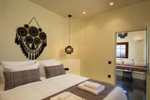 une chambre avec un grand lit blanc avec des oreillers dans l'établissement Legacy Private Villa ,Oia, à Oia