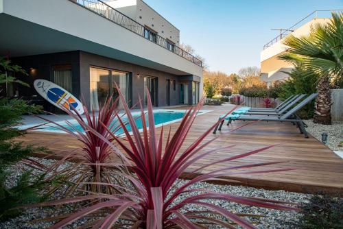 a house with a pool and a surfboard in a yard at luxury Villa One Way in Banjole