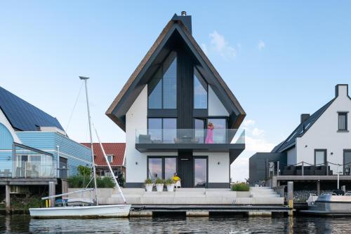 una casa en un muelle sobre el agua en B&B Ganzendiep aan het water en Grafhorst
