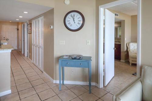 a blue table in a hallway with a clock on the wall at Windjammer 307 in Saint Augustine
