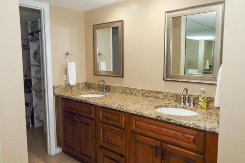 a bathroom with two sinks and two mirrors at Windjammer 307 in Saint Augustine