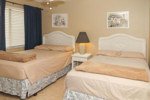 a bedroom with two beds and a lamp on a table at Windjammer 307 in Saint Augustine