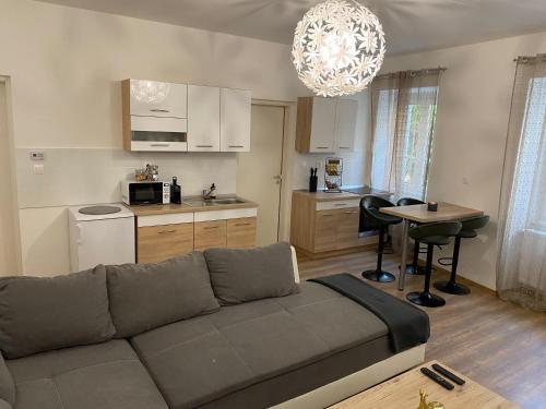 a living room with a couch and a kitchen at Várker 9 Apartman in Sopron