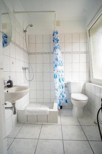 a bathroom with a shower and a toilet and a sink at Hotelik Maria in Szczytno