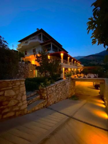 a house with a stone wall and a building at Royal 1967 in Himare