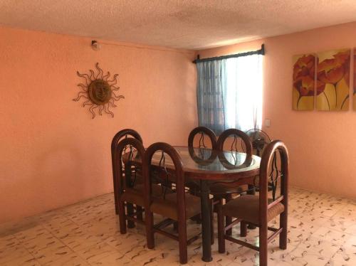 a dining room with a table and chairs and a window at Casa Estelar in Cancún