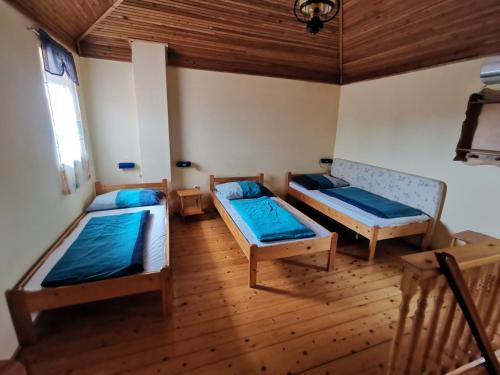 a room with two beds and a wooden floor at Anno 2000 in Balatonlelle