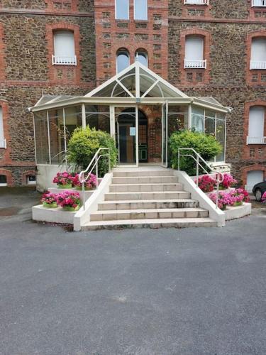 Un edificio con escaleras y flores delante. en Appartement pleine vue mer au bord de la plage, en Binic