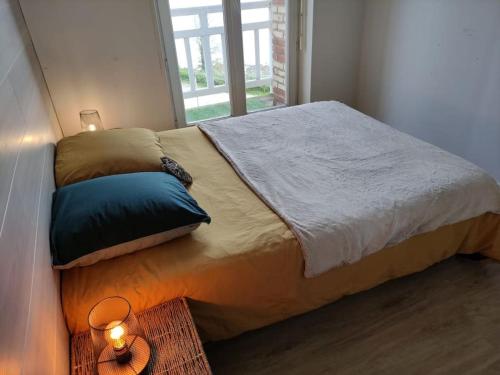 Bett in einem kleinen Zimmer mit Fenster in der Unterkunft Appartement pleine vue mer au bord de la plage in Binic