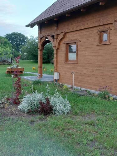 een gebouw met een gewelfde deuropening en een tuin bij Przytulisko in Smołdzino