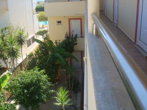 an empty balcony of a building with plants at Billy's Studios in Faliraki