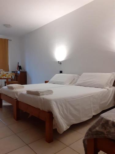 a bedroom with a large bed with white sheets at Agriturismo San Giuliano dei fratelli Giai in Susa