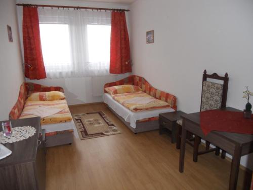 a room with two beds and a table and a desk at Motel Madona in Banská Bystrica