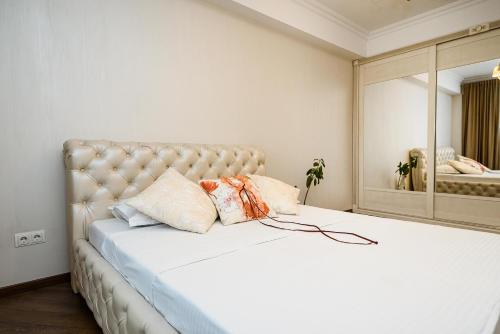 een slaapkamer met een groot wit bed en een grote spiegel bij NICE VIEW of THE CITY CENTER in Chişinău
