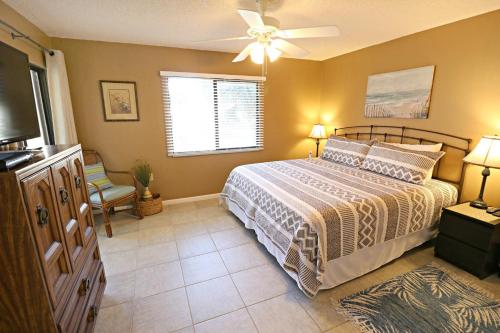 een slaapkamer met een bed en een plafondventilator bij Ocean Village Club G22 in St. Augustine