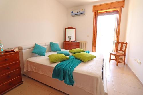 una camera da letto con un letto con cuscini blu e verdi di Casa Michelle Otranto a Otranto