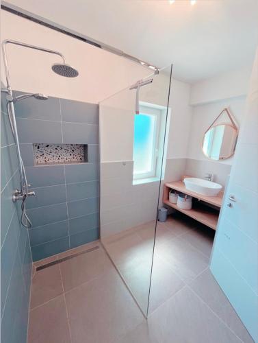 a bathroom with a glass shower and a sink at Seaview Apartment Villa Sia in Vantačići