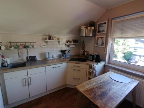 a kitchen with white cabinets and a table and a window at Romantische Ferienwohnung in Bad Breisig