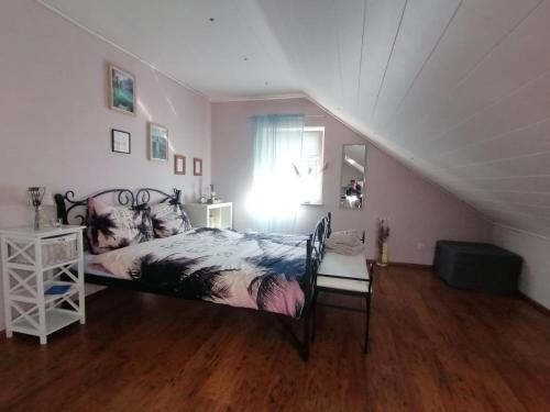 Romantische Ferienwohnung في باد برايسيغ: غرفة نوم بسرير ونافذة في العلية