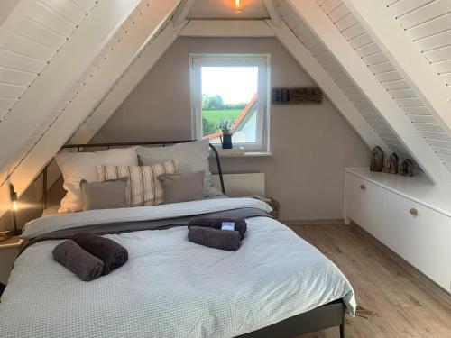 a bedroom with a large bed in a attic at Lille Schlei Hus in Boren