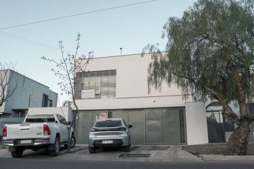 a truck and a pickup truck parked in front of a building at Departamento Soberania totalmente amoblado in La Cieneguita